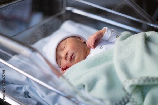 Obraz Close up portrait of adorable little newborn baby girl lying quiet at hospital crib hours after coming to life