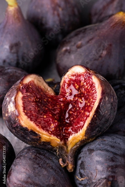 Fototapeta background with fresh and ripe figs, in the foreground an open fig forms a heart.
