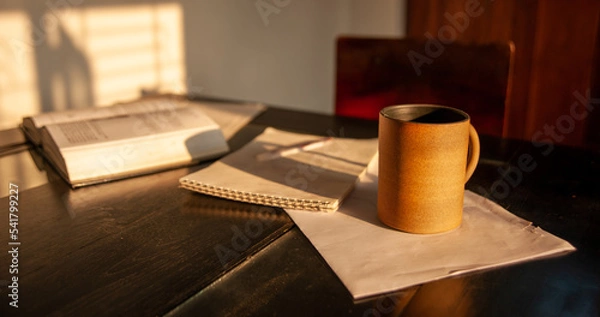 Obraz study table with chair long shadow, mug textbook and a notepad