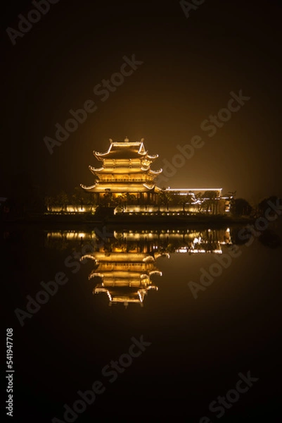 Fototapeta Illuminated Vietnamese temple on the water at night