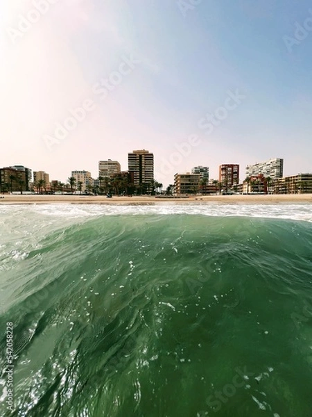 Fototapeta Wave against a beach with houses