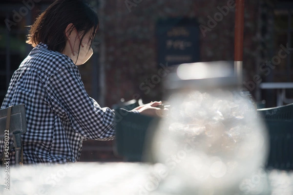 Obraz 屋外でテーブルに座る女性 前ボケ