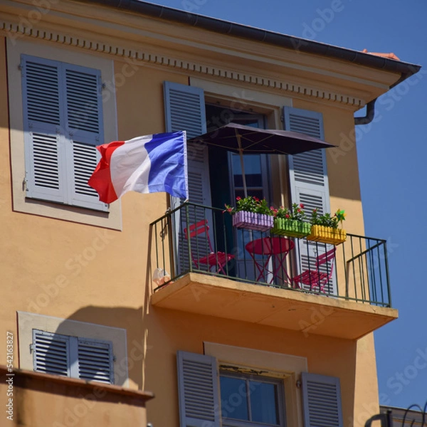 Fototapeta A balcony with plants, an umbrella, chairs, table and a France flag