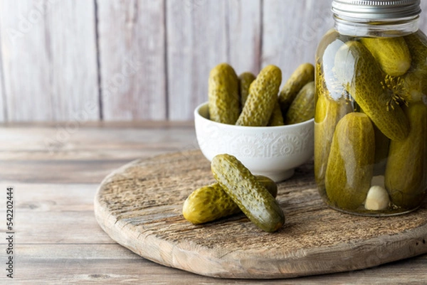 Fototapeta A jar of homemade dill pickles with a bowl full and pickles in front.
