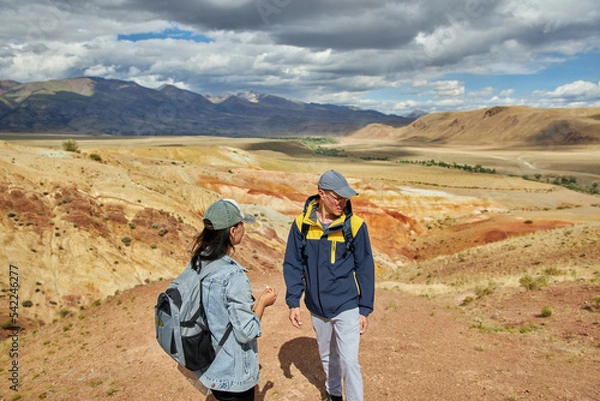 Fototapeta man and woman tourists on background of desert and hilly landscape on summer day. Sights of Russia, Siberia and Altai Republic, mars. Tourism and travel. Kosh-agach, Chagan-Uzun