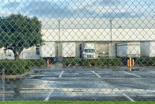 Fototapeta Loading dock behind a chain link fence.