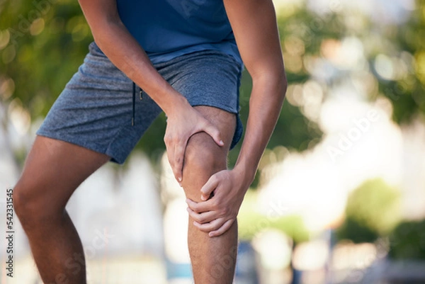 Obraz Knee pain, hands and man with injury during exercise, training and running in a park, pain and inflammation. Hand, fitness and arthritis in leg of runner during workout, sport and practice outdoors