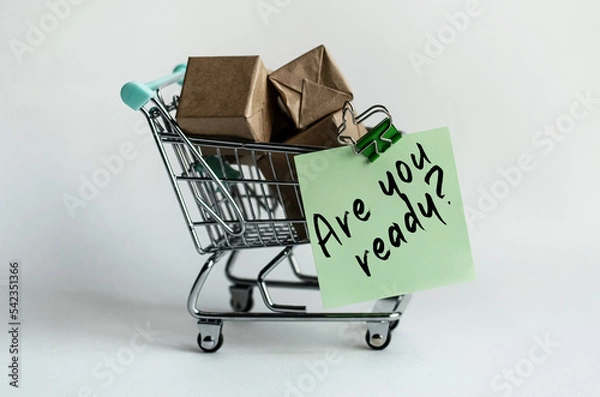Fototapeta A sticker attached to a decorative grocery cart along with small packaged mailboxes. The content of the inscriptions matters for stores, sales and marketing. 