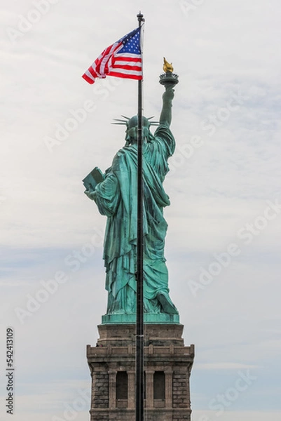 Obraz Back view of Liberty Statue with stars and stripes flag waving