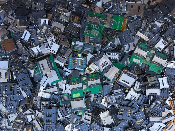 Fototapeta SIM card trays and SD card trays removed from mobile phones are e-waste parts that can be used to extract precious metals. Many SIM card tray backgrounds and SD card trays have Copy Space for Text