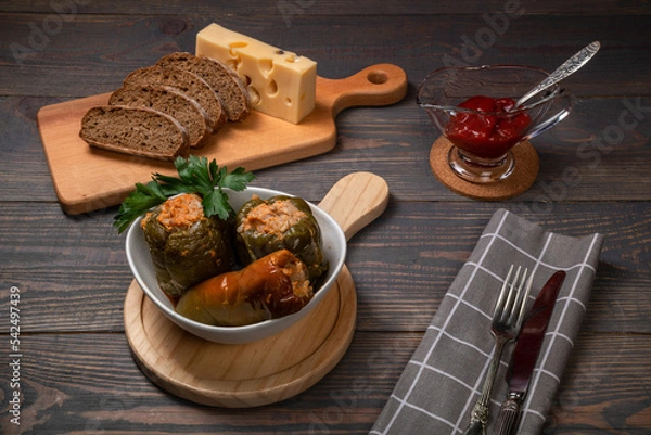Obraz stuffed bell peppers with cheese and sliced bread on a wooden background
