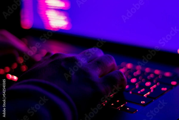 Obraz Female developer working in the dark. Focused on hands.