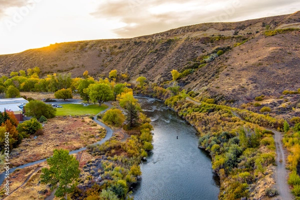 Obraz Aerial view of a beautiful River in Autumn with colorful trees, barren desert mountains, and a partly cloudy blue sky near Reno Nevada.