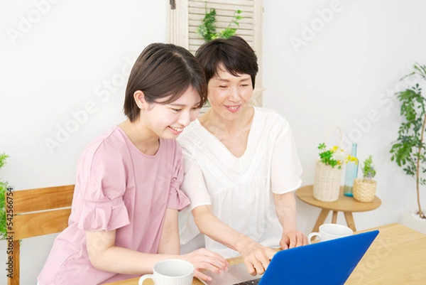 Fototapeta 自宅でパソコンを使う娘と母親