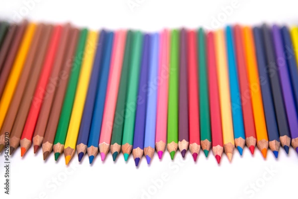Fototapeta colors pencils arranged in a clear  blurred background on a white background.