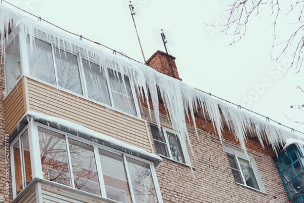 Obraz Russia. Terrible huge icicles formed on the balcony of a multi-storey building due to a poor roof storm system.