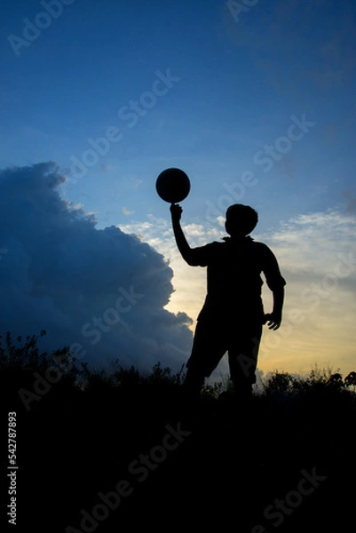 Obraz Silhouette of boy with football during sky sunset background, Silhouette of boy playing football 