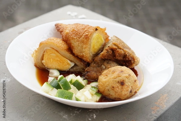 Fototapeta Pempek is a savoury Indonesian fishcake delicacy, made of fish and tapioca from Palembang. Pempek is served with sweet and sour sauce.