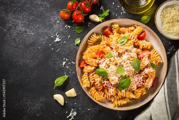 Fototapeta traditional italian kitchen. Italian pasta alla arrabiata with basil and parmesan on dark table. Top view with copy space.