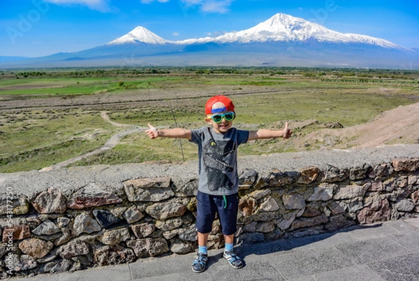 Fototapeta Little boy on the background of a beautiful view of mount Ararat in the afternoon. May 6, 2019. Armenia.