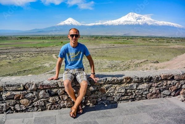 Fototapeta Young man on the background of a beautiful view of mount Ararat in the afternoon. May 6, 2020. Armenia.