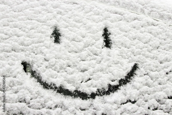 Fototapeta Winter decoration. Smiley face on a snowy car window. Hearty congratulations on the winter holidays. Creating a good mood. Background.