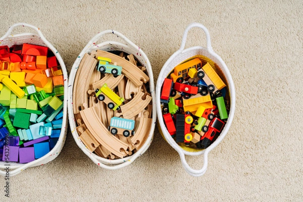 Fototapeta Colorful Toy Storage Baskets in the children's room. Cloth stylish Baskets with wooden toys. Organizing and Storage Ideas in nursery. Clean up toys and reduce the clutter. Top view