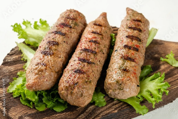 Obraz Sausages close-up grilled on a wooden crafting board, light background. Lula kebab. Without meat. Soy sausages.