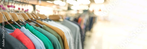 Obraz Banner. Clothes on hangers - new fashion collection at fashionable clothes store. Clothing rental, thrift shopping or seconhand store. Clothes stall against blurred store background with copy space