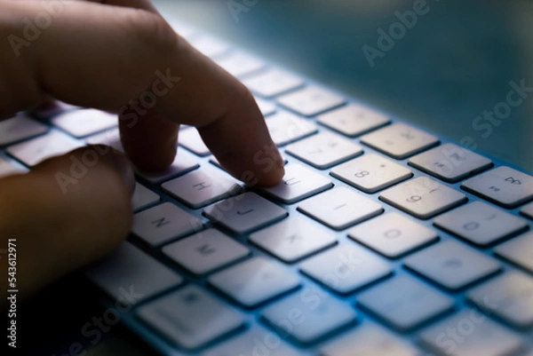 Fototapeta wireless computer keyboard with human hand close-up. toned
