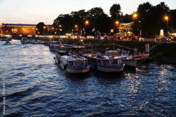 Fototapeta Saint Petersburg, Russia - August 19, 2022: Pleasure tourist ships at the city pier on the Admiralteyskaya embankment