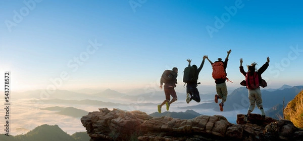 Fototapeta Group of happy hiker jumping on the hill