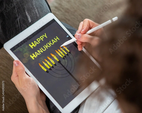 Fototapeta A Jewish boy draws a spin on a tablet for the holiday of Hanukkah