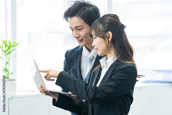 Fototapeta 笑顔でパソコンを見て話す日本人男女