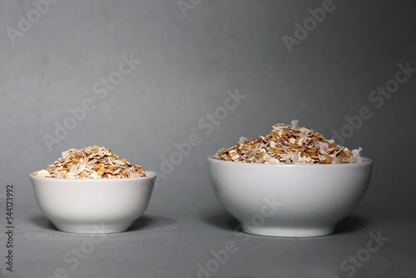 Obraz two white plates of oatmeal isolated on gray background
