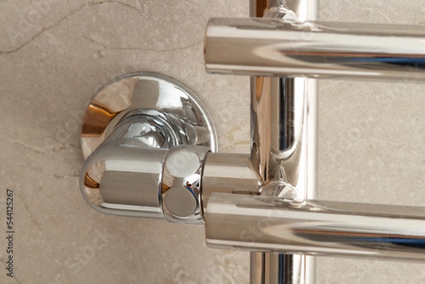 Obraz Modern new heated towel rail on a marble wall close-up