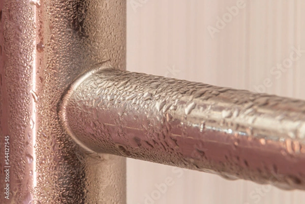 Obraz Wet heated towel rail covered with condensate. Close-up
