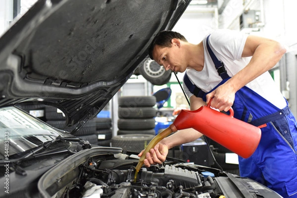 Fototapeta oil change from the engine of a car in a workshop by a professional mechanic - after-sales service