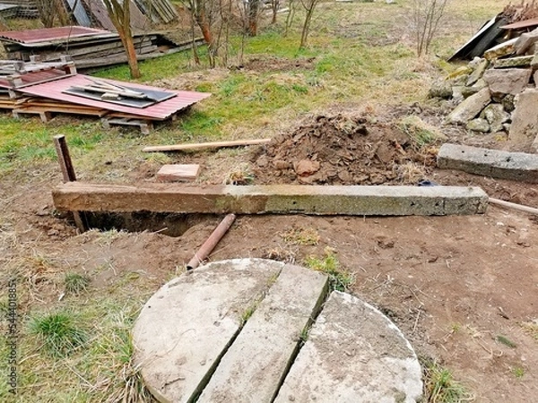 Fototapeta Hard work in the garden, pulling a concrete post out of the ground