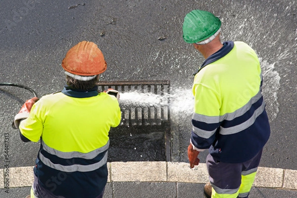 Obraz sewer workers working  for cleaning with water pressure on maintenance by the system sewage in city street