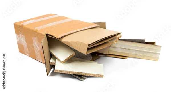 Fototapeta a pile of construction debris (plastic, MDF, aluminum, cardboard) in a brown cardboard box on a white background