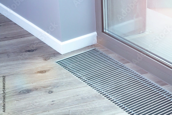 Obraz Floor convector heating metal grate built into the floor next to the window.