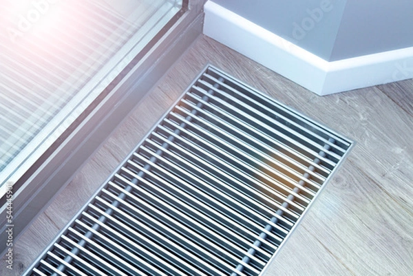 Obraz Metal grate for convector heating in the floor next to the window.