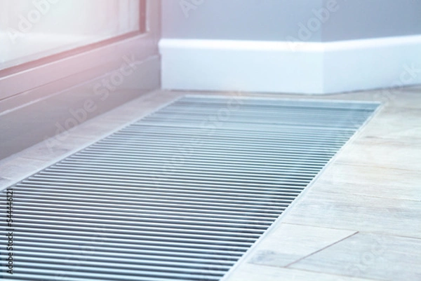 Obraz Floor convector heating metal grate built into the floor next to the window.