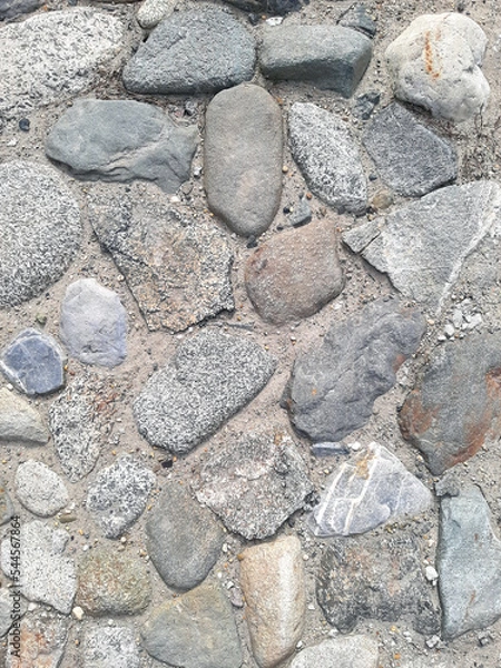Fototapeta Top view of a fragment of a dirt road. Rubble stones of different fractions on the ground. Abstract natural textured background. Drainage layer.