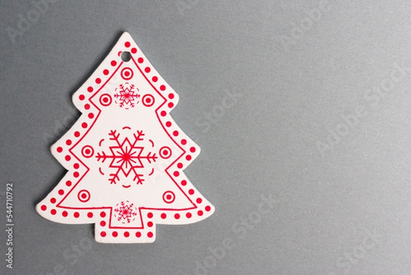 Fototapeta Close-up painted wooden figurine of a Christmas tree on a gray background. Clipping path. Copy space