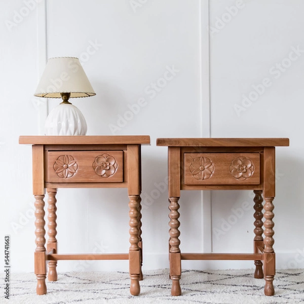 Obraz Front view of a picturesque pair of bed tables in a bright and white room illuminated under natural lighting