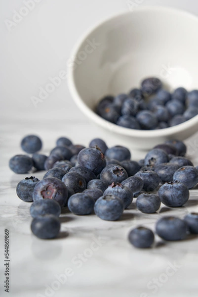 Fototapeta A group of fresh blueberries on a white and black marble table. 