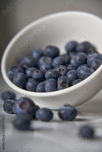 Fototapeta A group of fresh blueberries on a white and black marble table. 