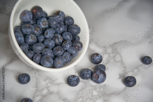 Obraz A group of fresh blueberries on a white and black marble table. 